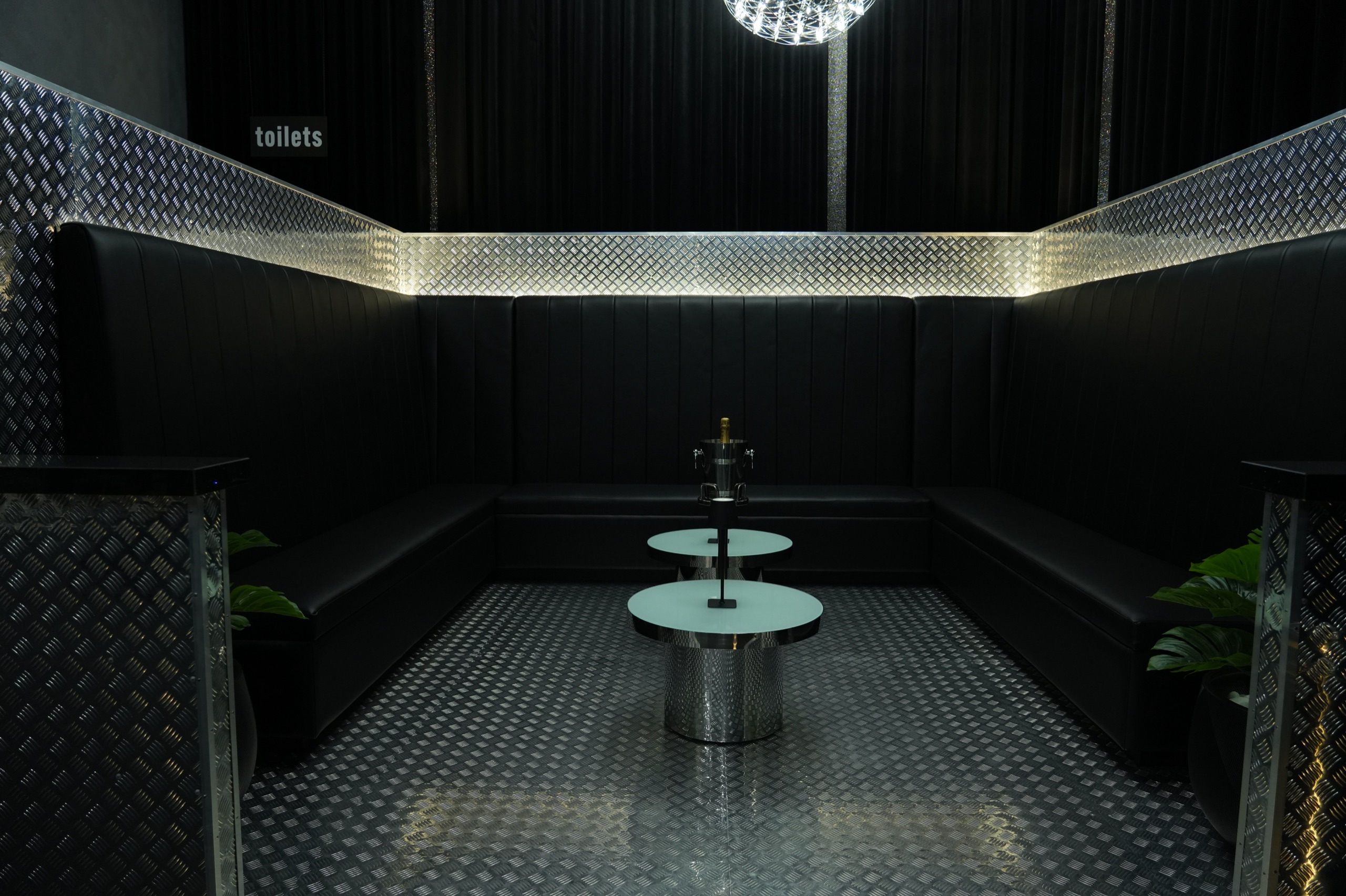 Tomiachi’s black-and-silver lounge with wraparound booth seating and cocktail tables